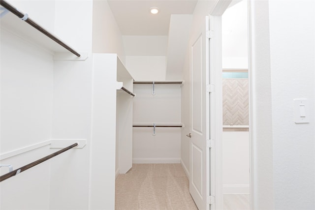 spacious closet featuring light colored carpet