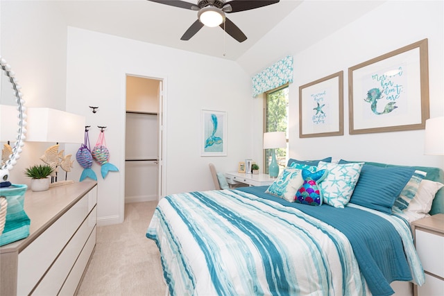 bedroom with light colored carpet, vaulted ceiling, ceiling fan, a spacious closet, and a closet