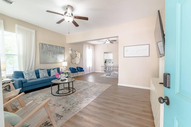 living room with dark hardwood / wood-style flooring and ceiling fan