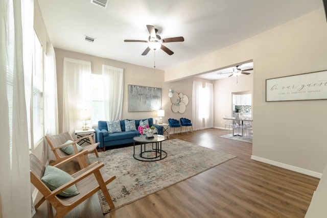 living room featuring ceiling fan and dark hardwood / wood-style flooring