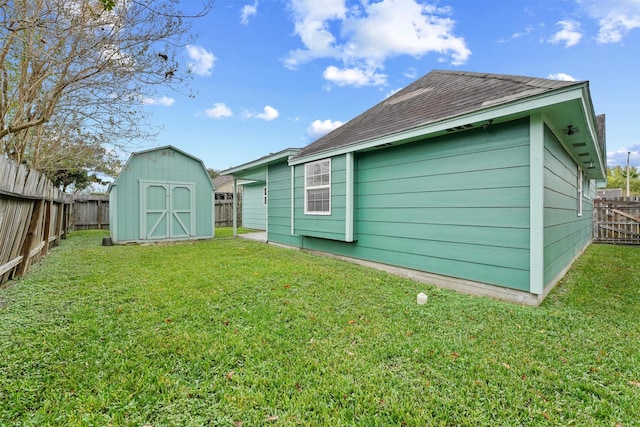 back of house with a yard and a shed