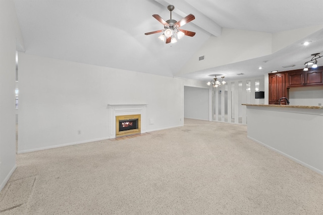 unfurnished living room with sink, lofted ceiling with beams, light colored carpet, and ceiling fan with notable chandelier