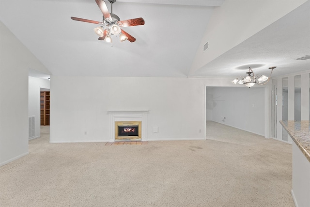 unfurnished living room with ceiling fan with notable chandelier, light colored carpet, and vaulted ceiling