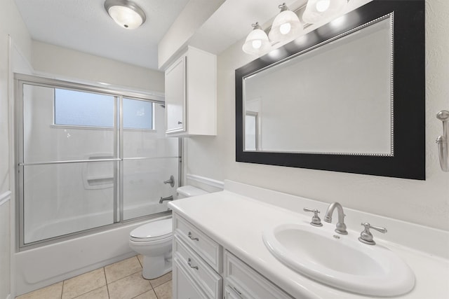 full bathroom with toilet, vanity, tile patterned floors, and bath / shower combo with glass door