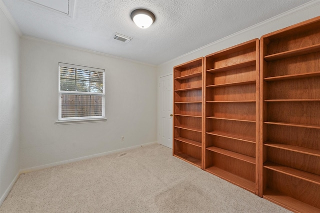 carpeted spare room featuring crown molding and a textured ceiling