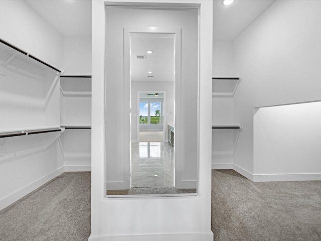 walk in closet featuring light colored carpet