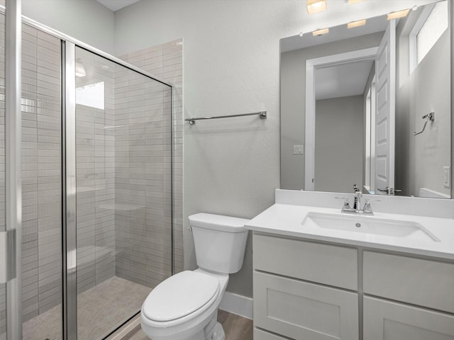 bathroom featuring vanity, toilet, and a shower with shower door