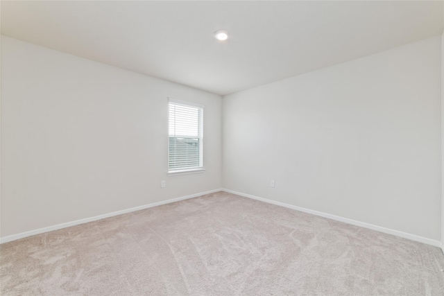 unfurnished room featuring light carpet