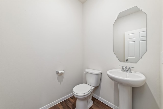 bathroom with hardwood / wood-style flooring, sink, and toilet