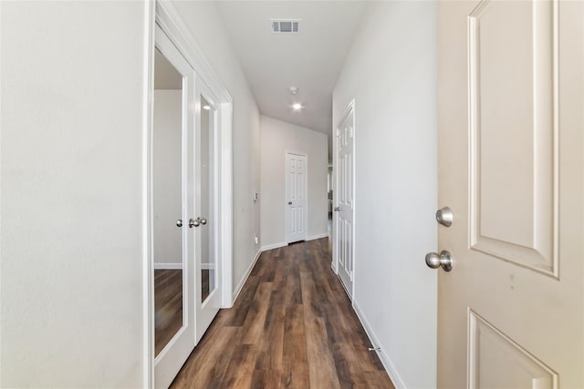 corridor with dark hardwood / wood-style flooring