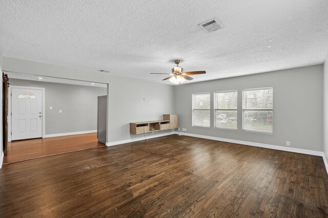 unfurnished living room with a textured ceiling, dark hardwood / wood-style floors, and ceiling fan