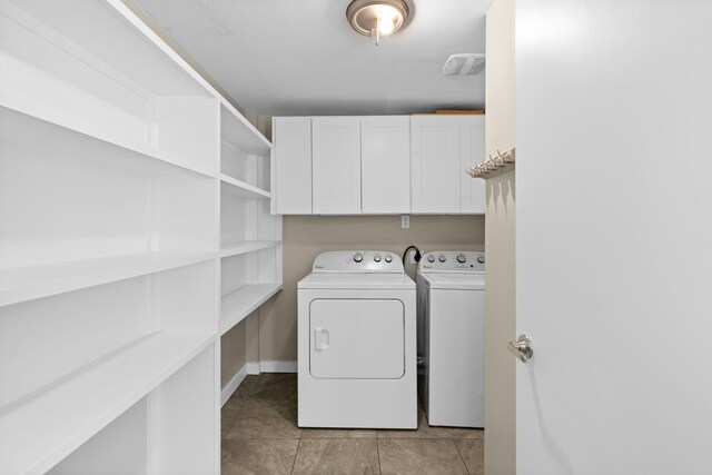 laundry room featuring cabinets, washing machine and dryer, and light tile patterned floors