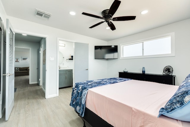 bedroom with ensuite bathroom, ceiling fan, and light hardwood / wood-style floors