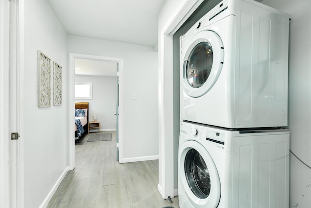 washroom featuring light hardwood / wood-style flooring and stacked washer / drying machine