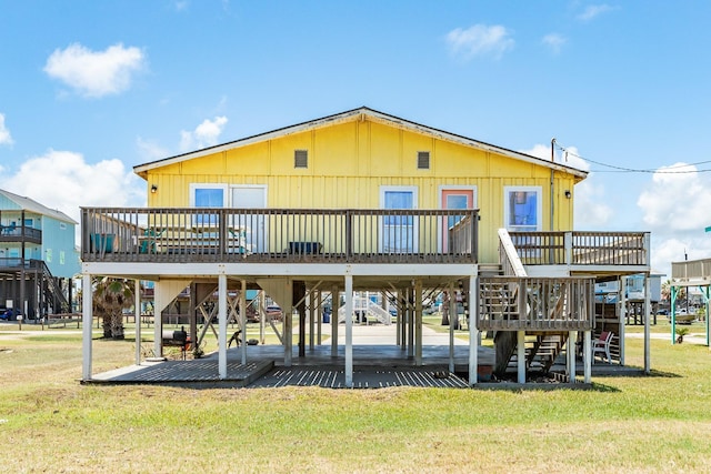 rear view of house featuring a wooden deck and a yard