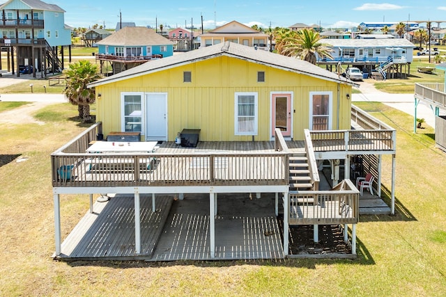 rear view of house with a lawn and a deck