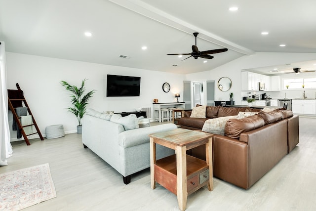 living room with vaulted ceiling with beams, ceiling fan, light hardwood / wood-style flooring, and sink