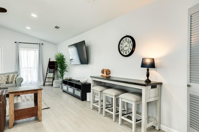 living room with lofted ceiling and light hardwood / wood-style flooring