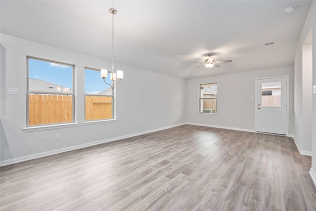 interior space featuring ceiling fan with notable chandelier and light wood-type flooring