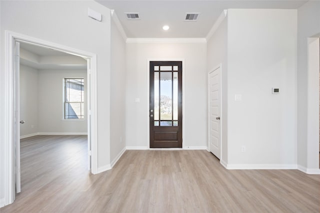 entryway with crown molding, a healthy amount of sunlight, and light wood-type flooring