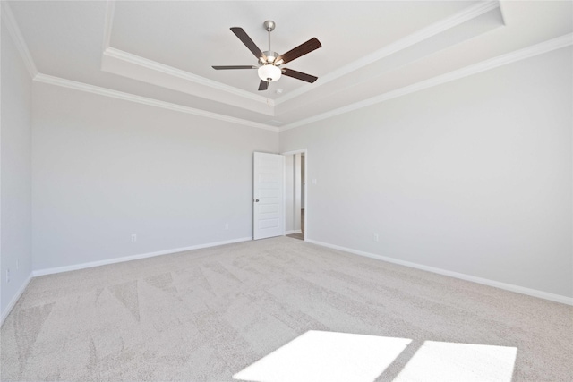 carpeted empty room featuring a raised ceiling and crown molding