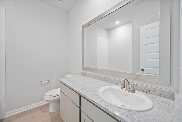 bathroom featuring vanity, toilet, wood-type flooring, and a shower