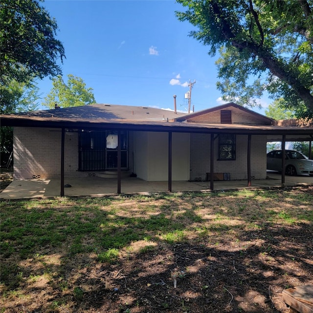 rear view of house with a lawn and a patio area