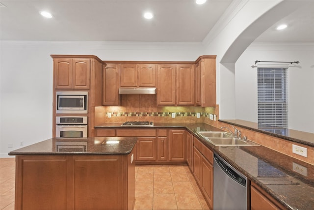 kitchen with dark stone counters, sink, stainless steel appliances, and ornamental molding