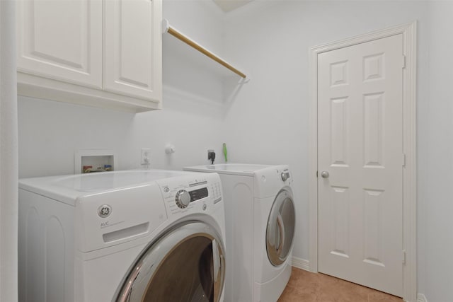 laundry area with washer and dryer, light tile patterned floors, and cabinets