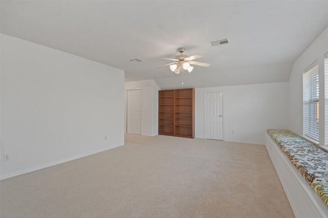 empty room featuring ceiling fan, light colored carpet, and lofted ceiling