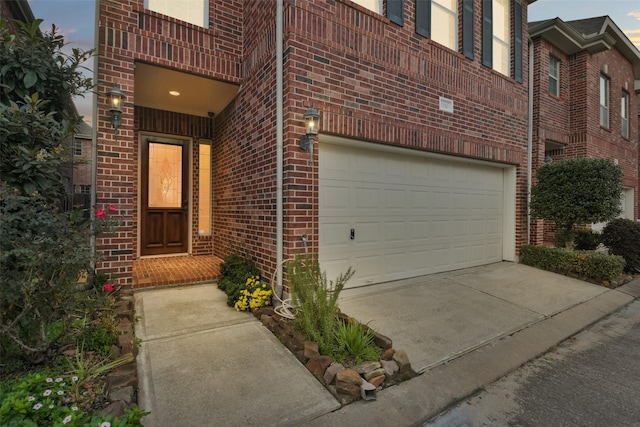 exterior entry at dusk featuring a garage