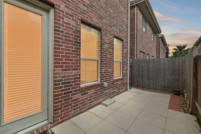 property exterior at dusk featuring a patio