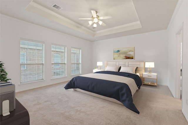 bedroom featuring a raised ceiling, ceiling fan, light colored carpet, and ornamental molding