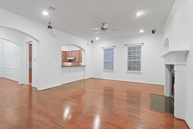 unfurnished living room featuring crown molding, ceiling fan, and hardwood / wood-style flooring