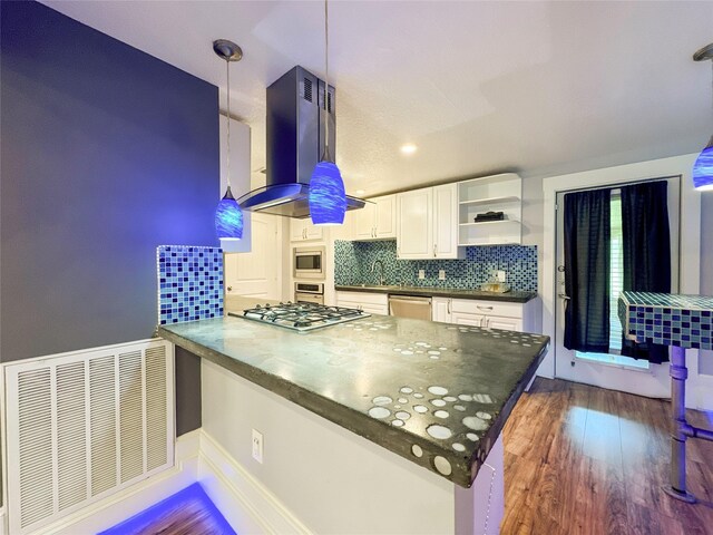 kitchen featuring kitchen peninsula, island exhaust hood, stainless steel appliances, pendant lighting, and white cabinetry