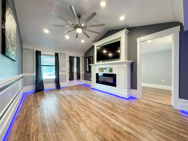 unfurnished living room with ceiling fan, lofted ceiling, crown molding, and light hardwood / wood-style flooring