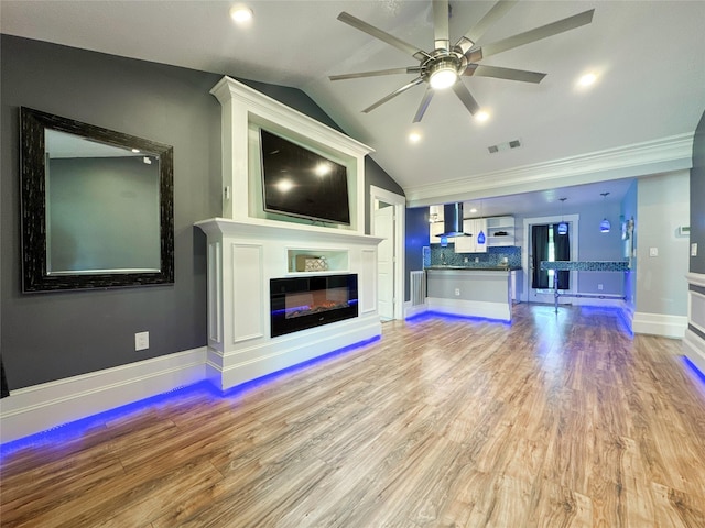 unfurnished living room with ceiling fan, crown molding, light hardwood / wood-style flooring, and vaulted ceiling