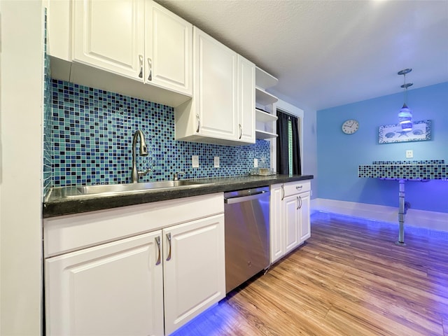 kitchen featuring white cabinets, backsplash, stainless steel dishwasher, and sink