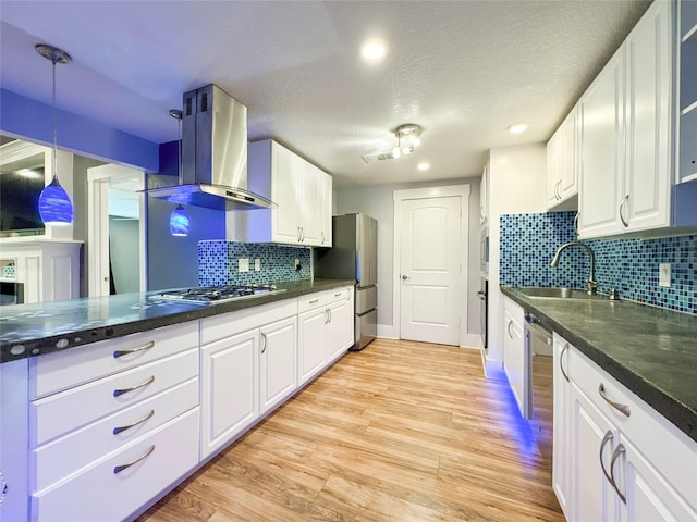 kitchen featuring white cabinets, wall chimney range hood, sink, light hardwood / wood-style flooring, and stainless steel appliances