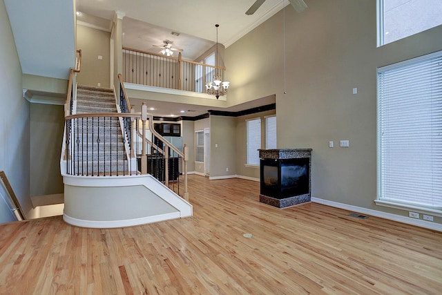 stairway with wood-type flooring, a multi sided fireplace, and a high ceiling