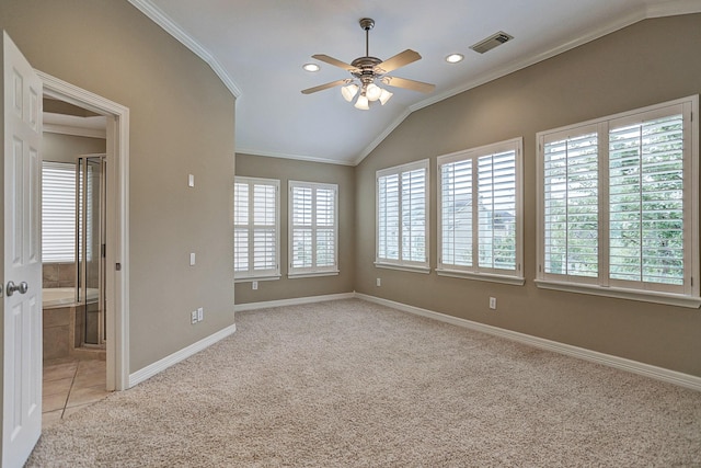 carpeted empty room featuring vaulted ceiling, ceiling fan, and crown molding