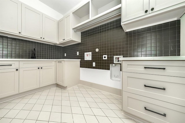 kitchen with a sink, open shelves, tasteful backsplash, light tile patterned flooring, and light countertops