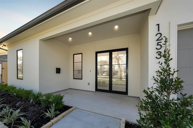 entrance to property featuring a patio area and stucco siding