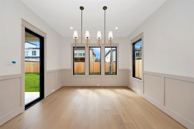 empty room with recessed lighting, light wood-type flooring, and wainscoting