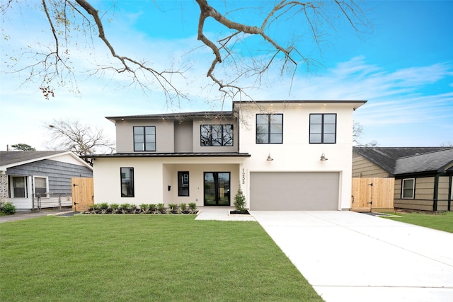 modern farmhouse style home with a front yard, a gate, stucco siding, concrete driveway, and a garage