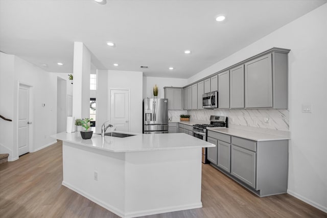 kitchen with decorative backsplash, stainless steel appliances, gray cabinetry, and sink