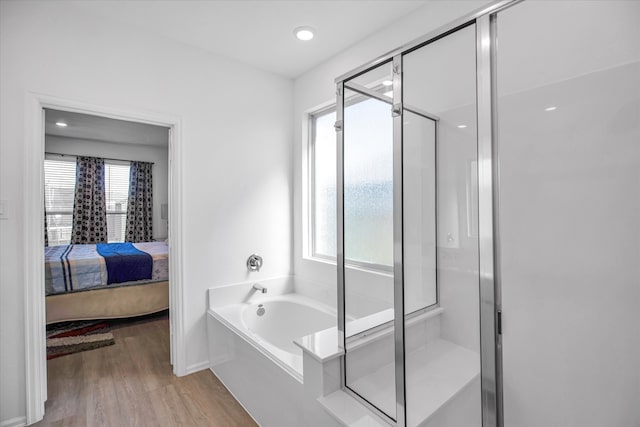 bathroom featuring hardwood / wood-style floors and separate shower and tub