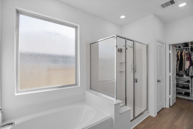 bathroom with hardwood / wood-style flooring, plenty of natural light, and separate shower and tub