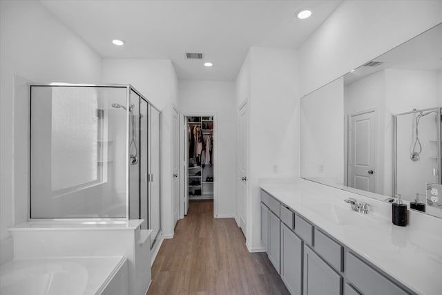 bathroom with vanity, wood-type flooring, and independent shower and bath