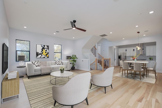 living room featuring light hardwood / wood-style floors and ceiling fan